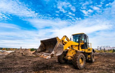 yellow-tractor-levels-ground-new-house-construction